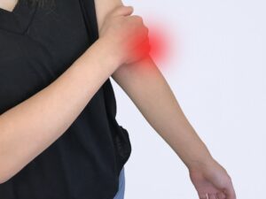腕の痛みを押さえる女性