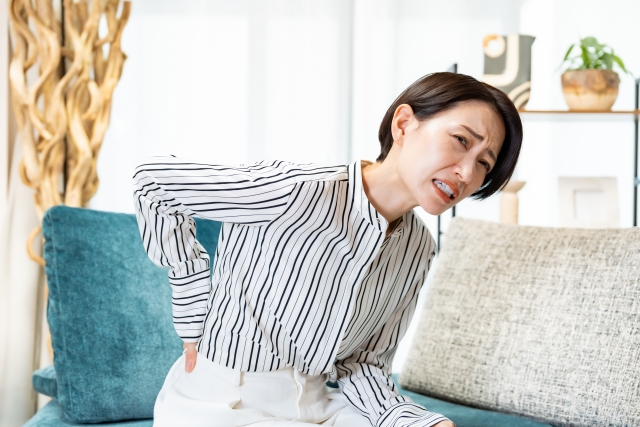 腰を押さえる女性
